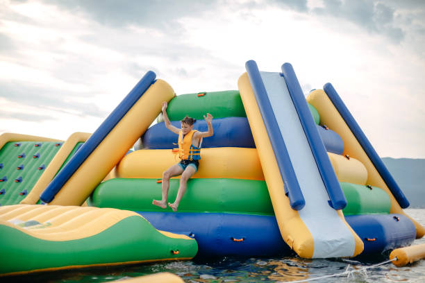 Kid having fun in Water Park Boy enjoying in Water park jumping in water top of water slide photos stock pictures, royalty-free photos & images