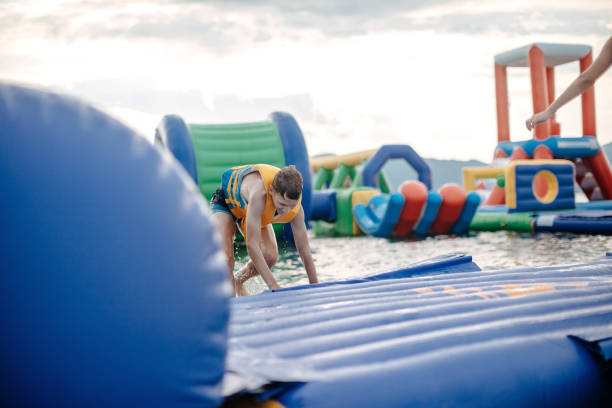Kid having fun in Water Park Boy enjoying in Water Park trying to keep balance top of water slide photos stock pictures, royalty-free photos & images