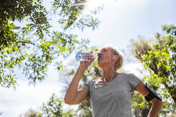 istock Mature woman drinking water while exercising 1411697218