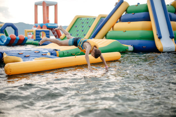 Kid having fun in Water Park Boy enjoying in Water Park jumping in water top of water slide photos stock pictures, royalty-free photos & images