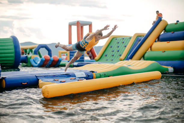 Kid having fun in Water Park Boy enjoying in Water Park jumping in water top of water slide photos stock pictures, royalty-free photos & images