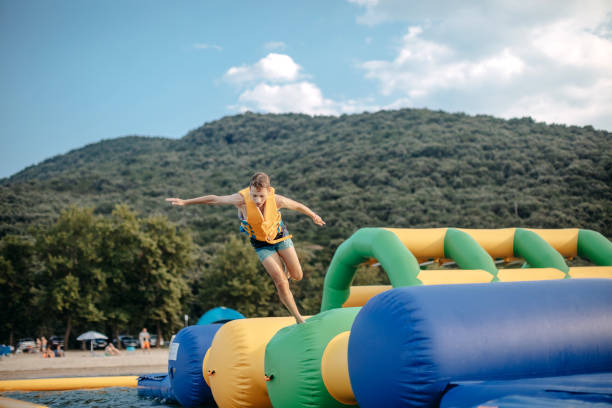 Kid having fun in Water Park Boy enjoying in Water Park jumping in water top of water slide photos stock pictures, royalty-free photos & images