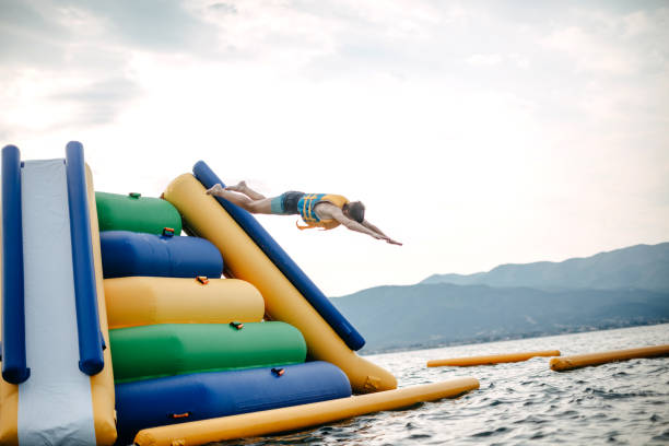 Kid having fun in Water Park Boy enjoying in Water Park jumping in water top of water slide photos stock pictures, royalty-free photos & images
