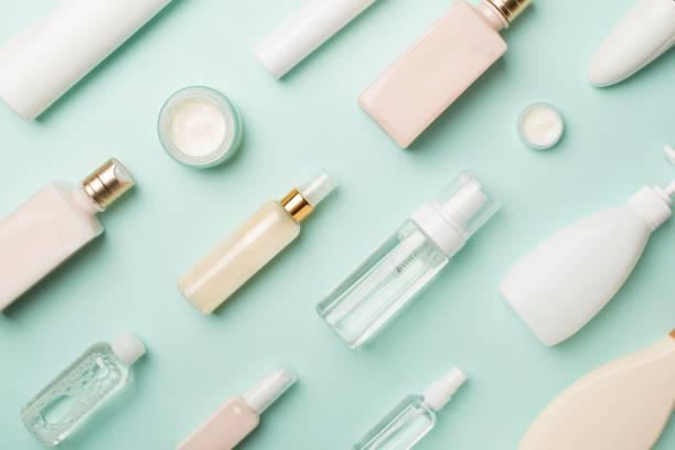 istock Different cosmetic bottles on color background, top view 1411698697