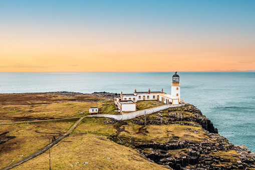 Coastline in Scottish Highlands with a steep Cliff and Neist Point Lighthouse at sunset