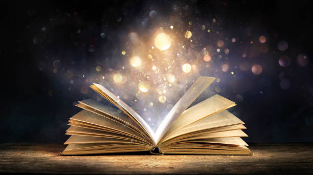 libro magico con glitter - libro aperto con luci che brillano su sfondo scuro - narrare storie foto e immagini stock