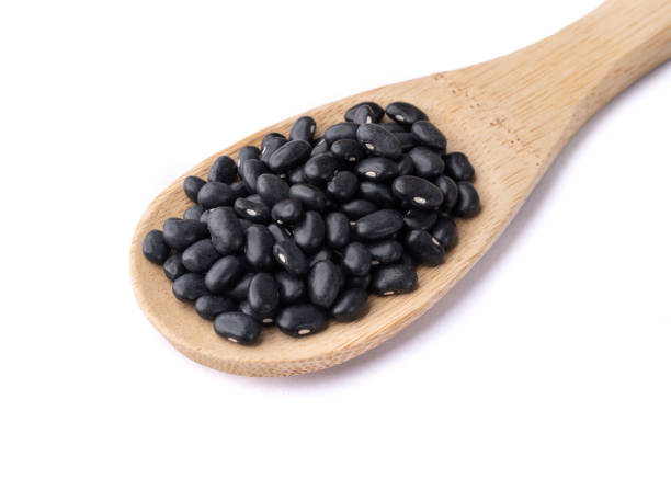 istock Black beans on a spoon isolated over white background 1411701996