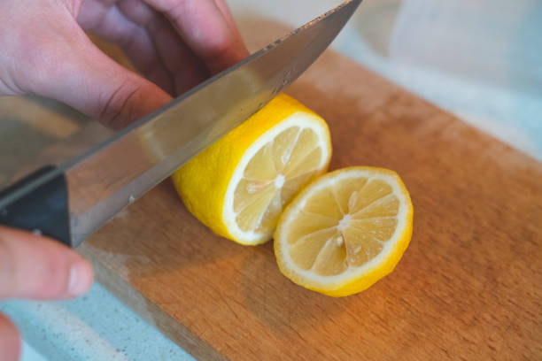 istock A woman cuts a lemon on a wooden kitchen board 1411702031