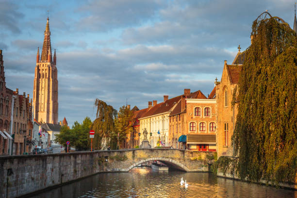 istock Rozenhoedkaai canal reflection at sunrise and blurred clouds, Bruges 1411702051