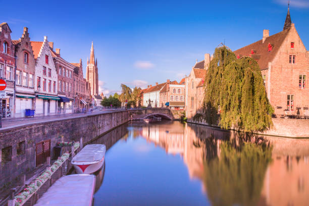 istock Rozenhoedkaai canal reflection at sunrise and blurred clouds, Bruges 1411702893
