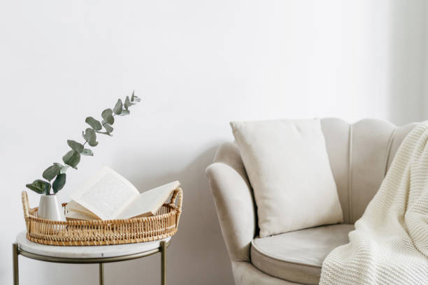 open book on tray in room, near beige armchair with pillow - side table imagens e fotografias de stock