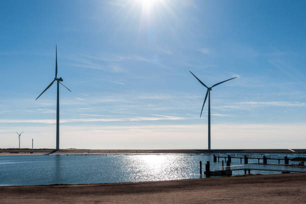 Wind turbine on dyke, at the water's edge of North Sea, in Vrouwenpolder, Zeeland, Netherlands.