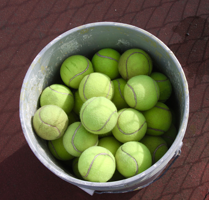 A bucket of tennis balls ready for a tennis practice