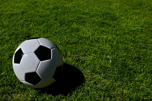 A traditional soccer ball lies on the pitch prior to a game.
