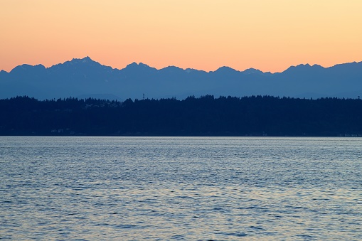 During the summer, the sun sets over Puget Sound far to the northern horizon in Edmonds, Washington.