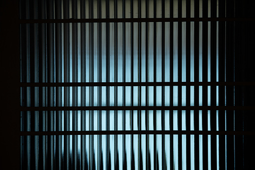 Goiania, Goiás, Brazil – July 29, 2022:  Photograph of a detail of the textured glass of a door with backlighting.