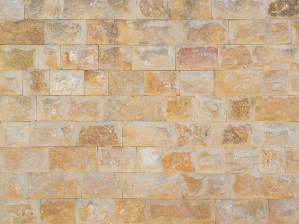 istock Travertine masonry texture. Facade cladding. Wall with orange rough masonry. Full screen photo. Not seamless texture 1411712220