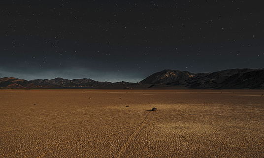 Rock traces track across cracked sand of the Racetrack Playa in Death Valley