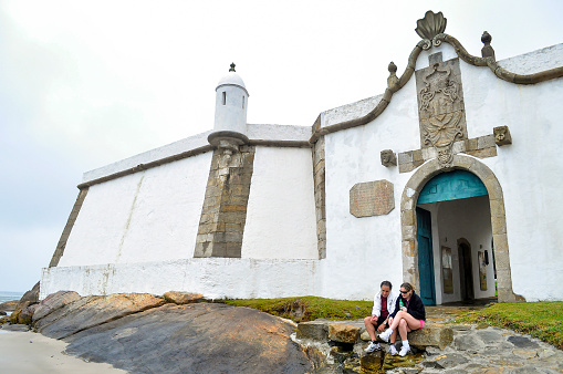 Ilha do Mel, Parana, Brazil - Jul 24th, 2010: A couple sitting in front of Our Lady of Pleasures Fortress