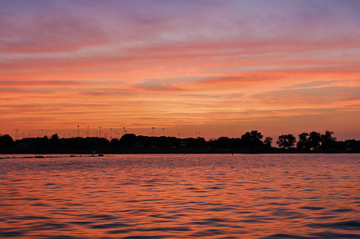 A view from the lake of the tree line after sunset