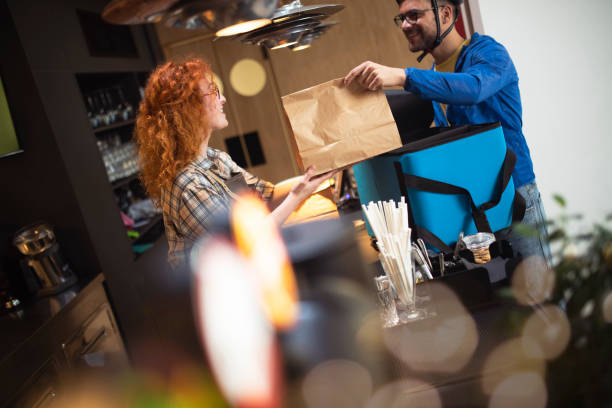istock The waitress and delivery man chat while the delivery man takes orders from her. 1411727422