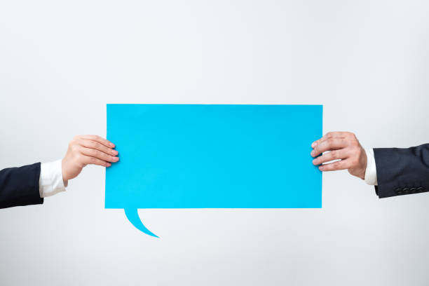 istock Business Team Holding Important Information On Speech Bubble On Both Sides. Executives Presenting Crutial Messages On Dialogue Balloon. Man And Woman Showing Recent Ideas. 1411727682