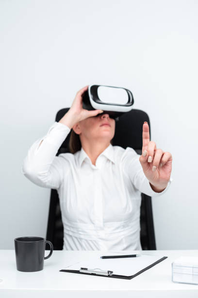 istock Businesswoman Wearing Virtual Reality Goggles And Learning Professional Skill Through Futuristic Simulation. Woman Gesturing While Sitting At Desk During Modern Training. 1411727725