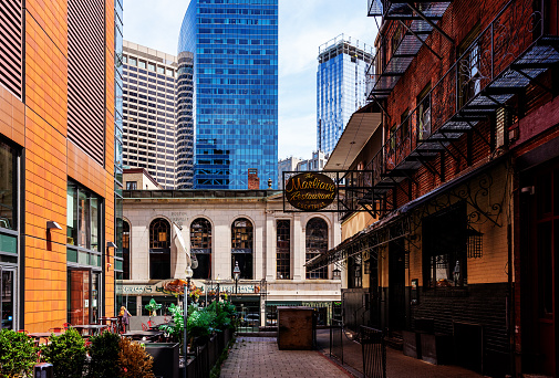 Boston, Massachusetts, USA - July 27, 2022: A view of old and new buildings in downtown Boston as seen down a small side street.
