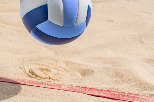 Ball on Summer Sandy Beach against blue sky background