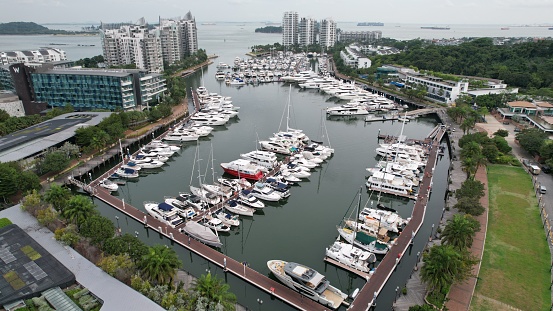 Aerial view of luxury yachts docked in the Sentosa Island, Cove area, in Singapore. Taken during day time. The area was around some hotels and condominiums