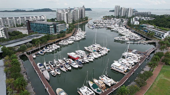 Aerial view of luxury yachts docked in the Sentosa Island, Cove area, in Singapore. Taken during day time. The area was around some hotels and condominiums