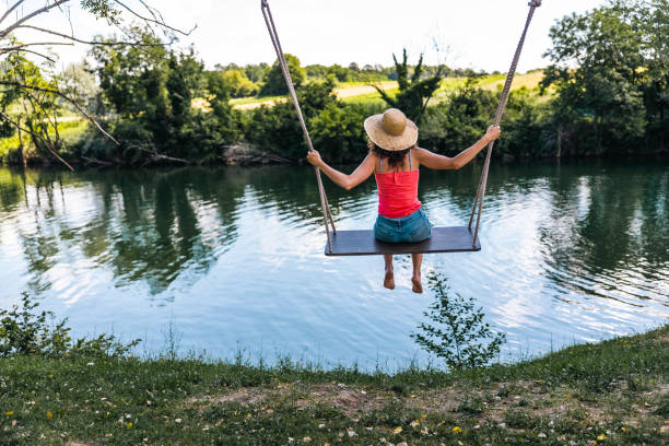 woman on a beautiful swing by a river - river kolpa imagens e fotografias de stock