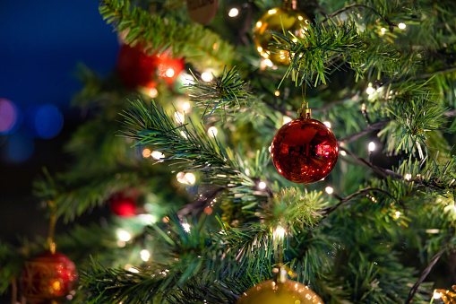 Close-up on beautiful Christmas ornaments hanging on the tree - holidays concepts