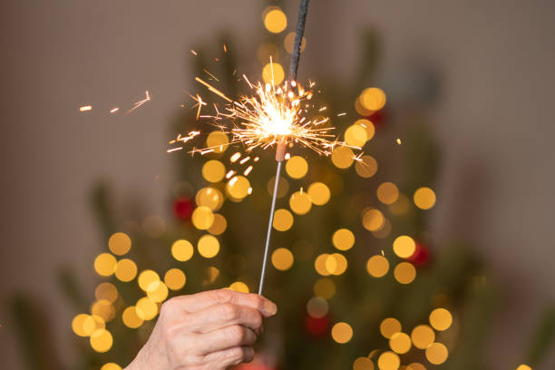 istock Sparkling beautiful sparkle or bengal lights against Christmas tree. Golden magic lights. Holiday , birthday or party concept. 1411739317