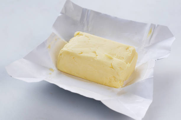 istock slice of a butter on a paper on table 1411740023