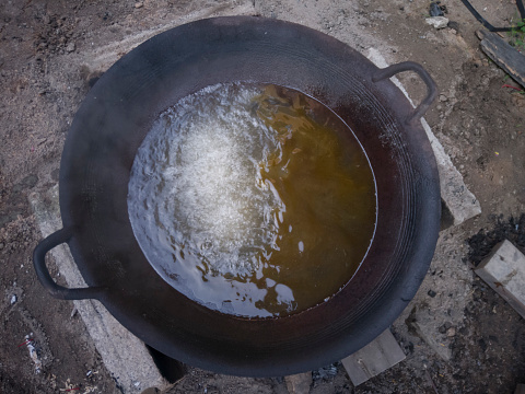 Top view of Water mixed with boiling oil, half a large pan, Because putting firewood not around the stove.