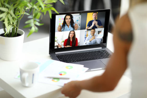 istock Woman talking with international colleagues using online video chat service at workplace 1411750789