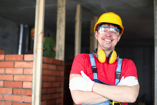 istock Happy builder stands near brickwork and smiles 1411750807