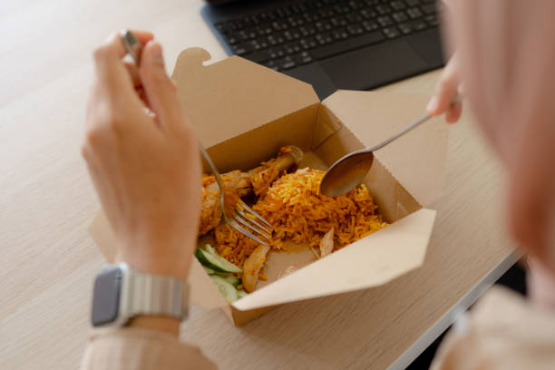 istock Asian Muslim woman eating while working at home 1411752731