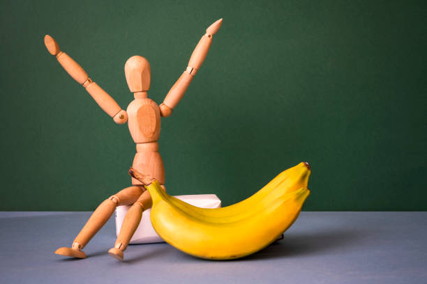 Wooden man sits next to a banana