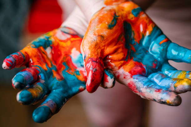 Closeup of woman hands dirty with acrylic paint. Creative finger painting. stock photo