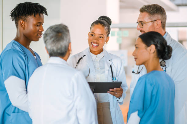 istock Doctors and nurses using digital tablet to plan hospital treatment for patient and share clinic schedule. Diverse group of medical professionals using test results on technology to brainstorm cures 1411759585