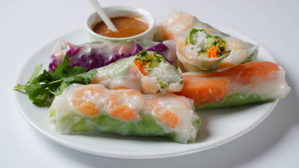 ベトナムの春巻きゴイクオンまたはネムクオン、エビ、ハーブ、米の春雨、野菜でいっぱいです。ホイシンとピーナッツソースのディップを添えてお召し上がりください。 - rolled up rice food vietnamese cuisine ストックフォトと画像