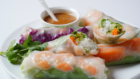 Vietnamese Spring Rolls Goi Cuon or Nem Cuon,  filled with prawns, herbs, rice vermicelli and vegetables. Served with hoisin and peanut sauce dip.