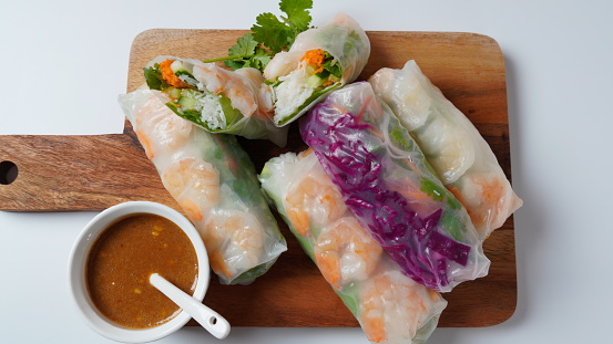 Vietnamese Spring Rolls Goi Cuon or Nem Cuon,  filled with prawns, herbs, rice vermicelli and vegetables. Served with hoisin and peanut sauce dip.