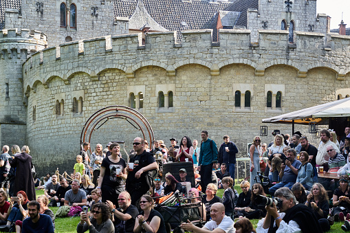 Pattensen, Germany, June 4, 2022: Group of people watching a spectacle in front of the walls of a historic castle