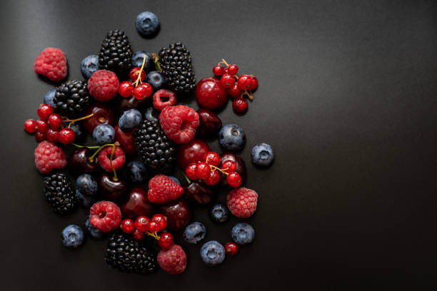 Berries are placed in a pile on a dark background