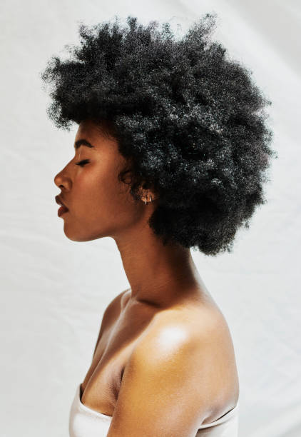 스튜디오에서 흰색 배경에 고립 된 아프리카 여성의 측면 프로필. 곱슬 머리를 가진 아름다운 여성이 화장품을위한 완벽한 피부를 보여주고 메이크업 제품을위한 자연의 아름다움 - african ethnicity beauty curly hair confidence 뉴스 사진 이미지