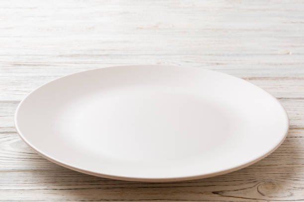 istock Perspective view of empty light plate on wooden background. Empty space for your design 1411775997