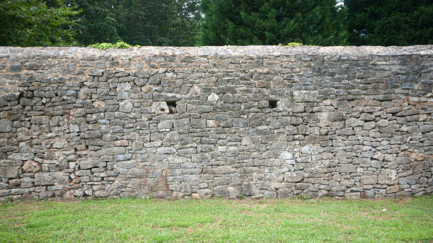 istock Grey stone wall in a green park 1411776225